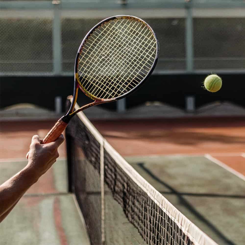 Ein Mann schlägt den Tennisball.