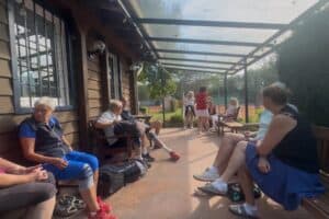 Mitglieder des TC Forstwald unterhalten sich beim Kartoffelcup 2026 auf der überdachten Terrasse